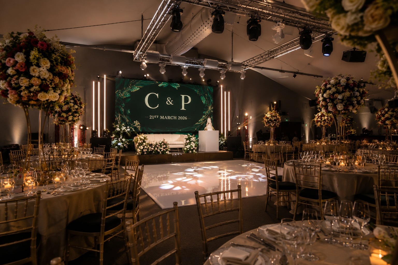 Gala dinner production in The King Suite at Easthampstead Park, with stage set, truss lighting and floral styling