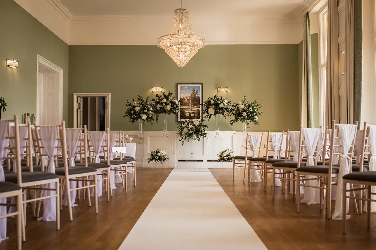 Elegant ceremony room inside the mansion at Easthampstead Park, with chandelier and floral styling
